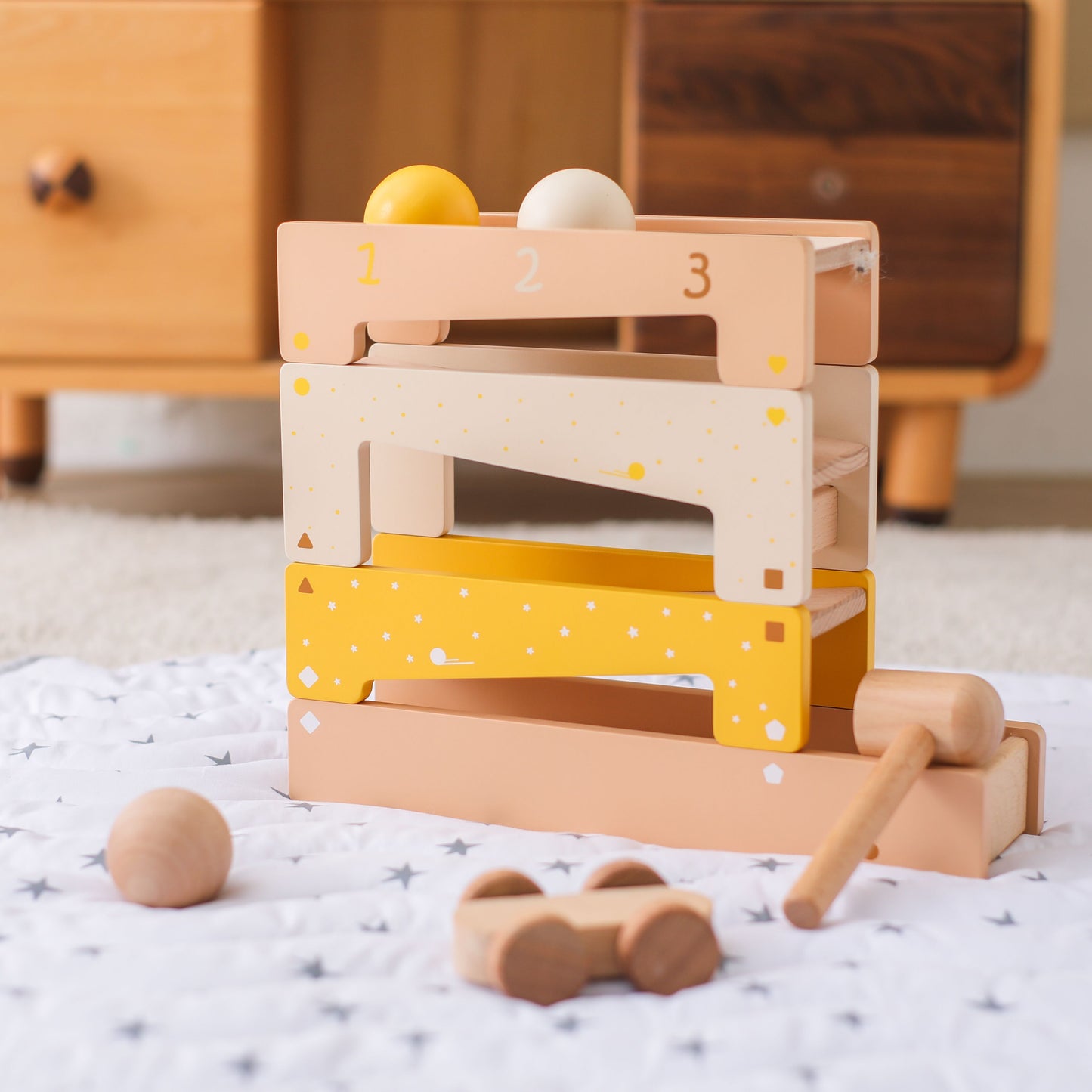 Kind spielt mit Klopfbank, Kugelbahn und Holzhammer, Montessori-Spiel