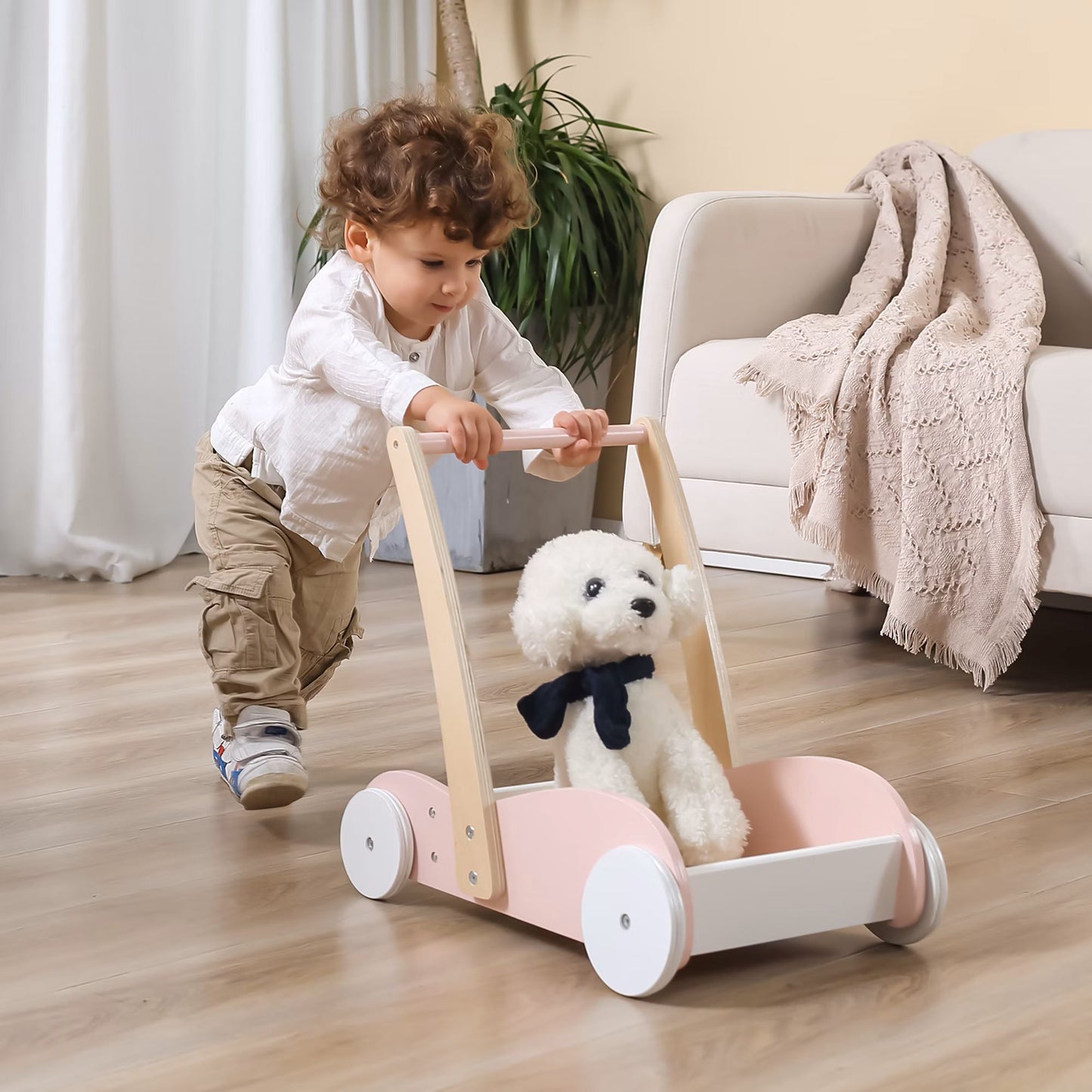 Kleinkind schiebt naturfarbenen Holz-Lauflernwagen mit Kuscheltier – Spielzeug ab 1 Jahr für drinnen