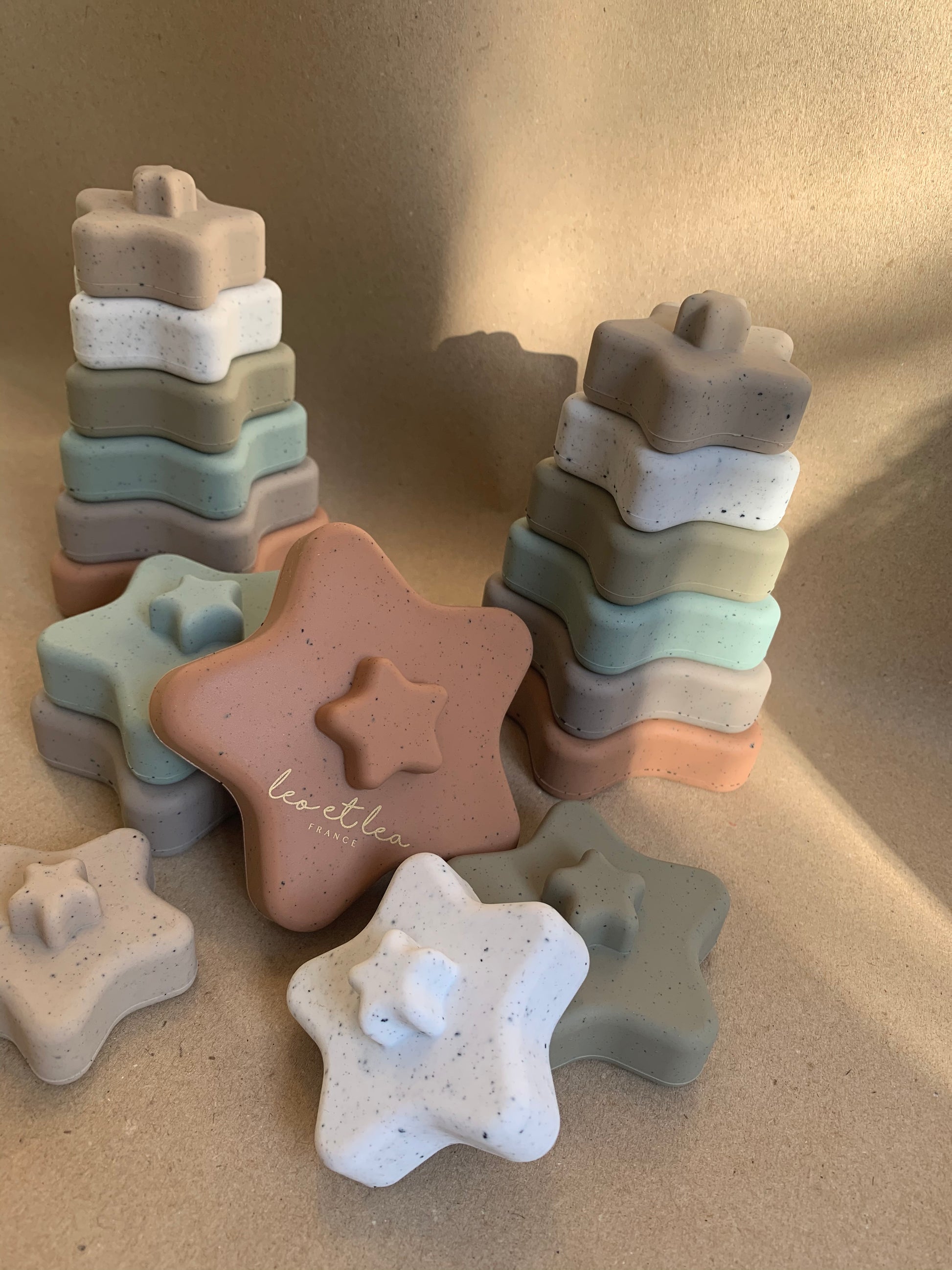 Bunte Stapelspielzeuge in Sternform aus Silikon, farblich sortiert in Naturtönen, ideal für Babys ab 6 Monaten zum Greifen und Stapeln