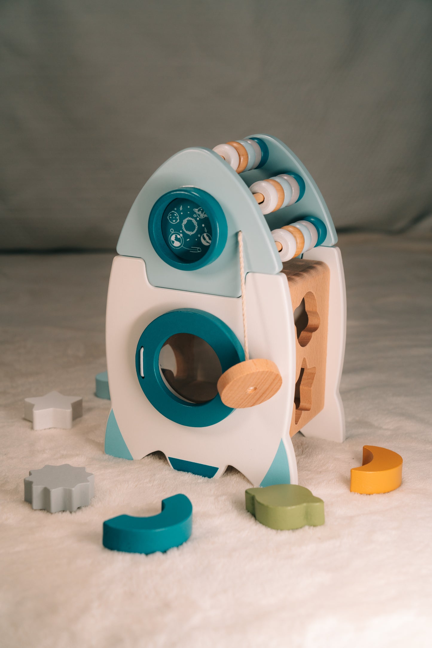 Kleinkind spielt mit der Spielbox-Rakete aus Holz