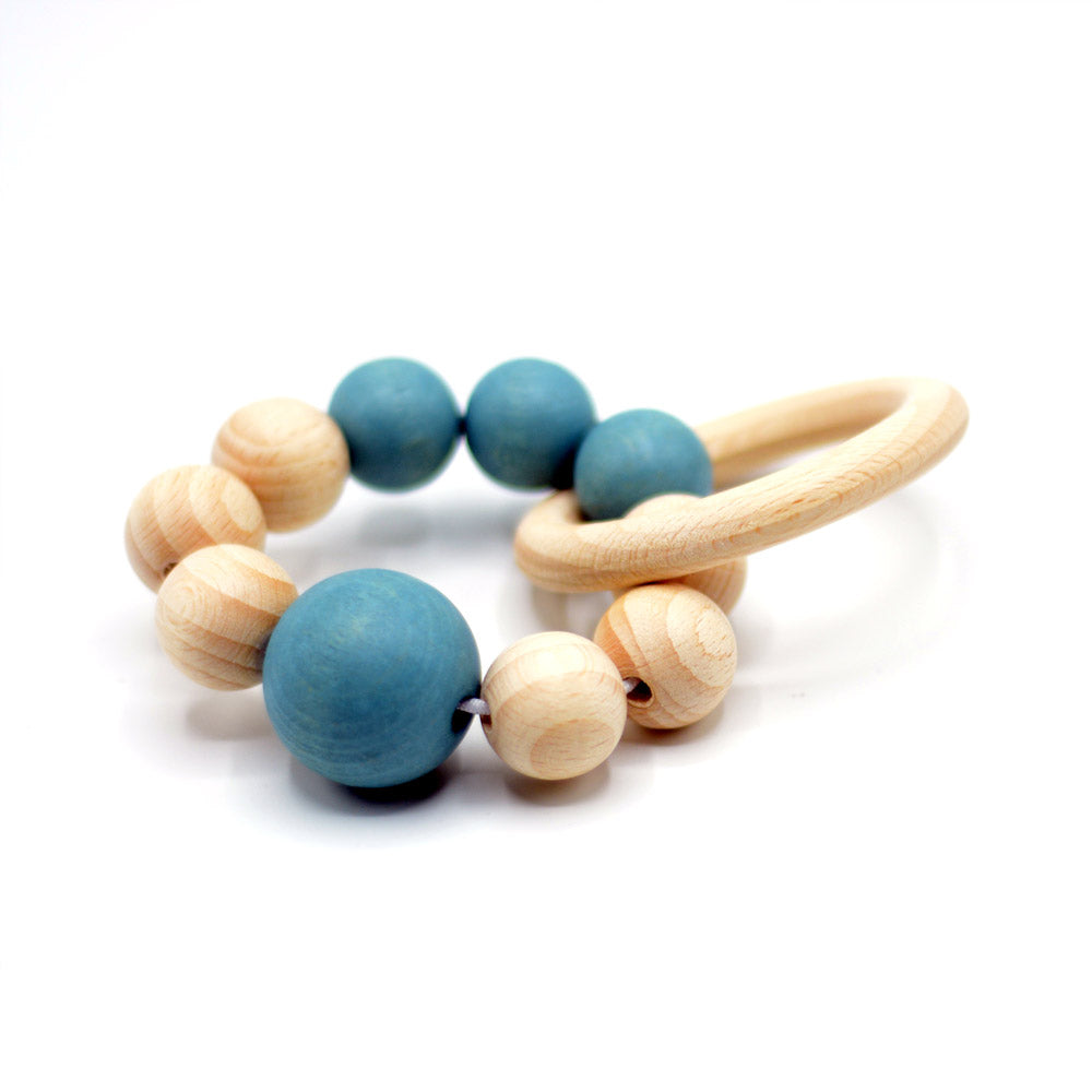 Handgemachter Baby-Greifling mit blauen Filzkugeln und hellem Holzring, sensorisch wertvoll und sicher